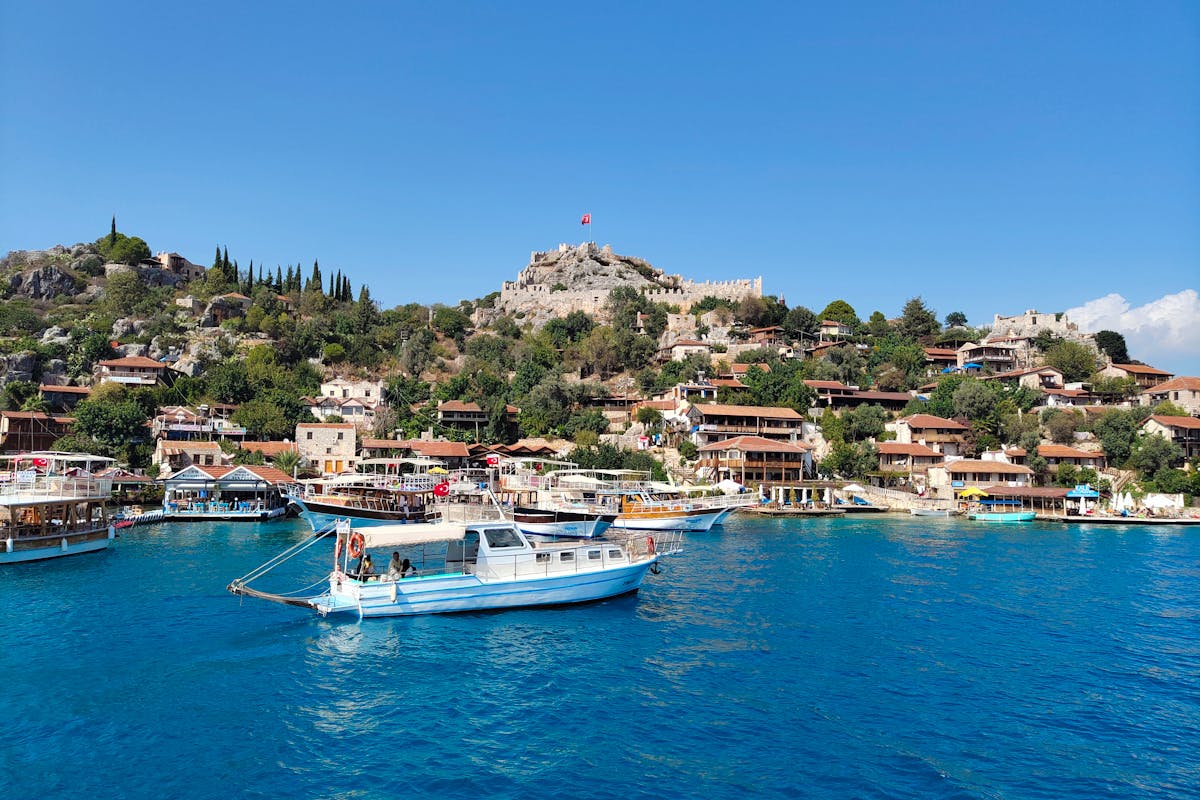 Antalya Kaleköy (Simena)’da kale manzarası ve turkuaz deniz kıyısındaki taş evler